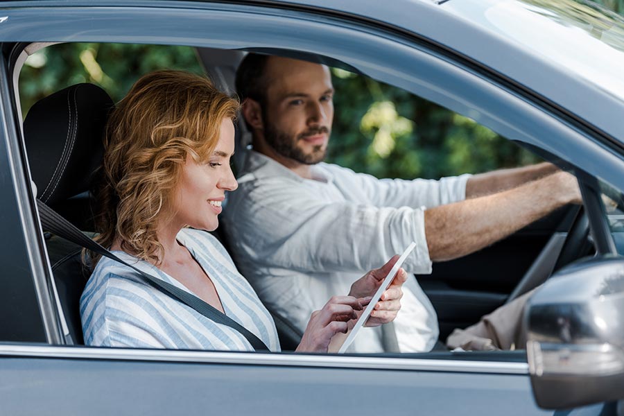 Blog - Couple in a Car, Wife in the Passenger Seat Using Her Phone